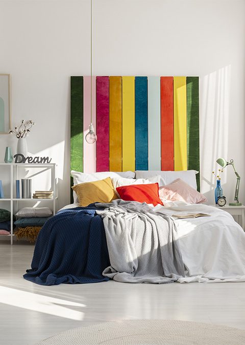 Colorful bedroom interior with rainbow colored bedhead