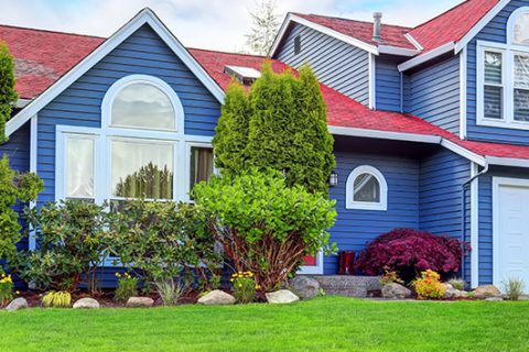 Beautiful curb appeal with blue exterior paint and red roof.