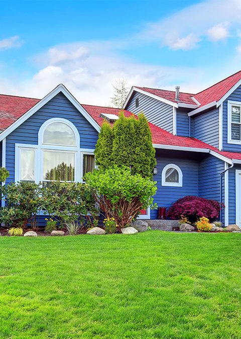 Beautiful curb appeal with blue exterior paint and red roof.
